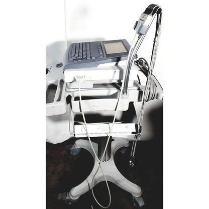 Medical mac1600 ecg analysis system with gray control panel white trays and metallic cables on cart stand