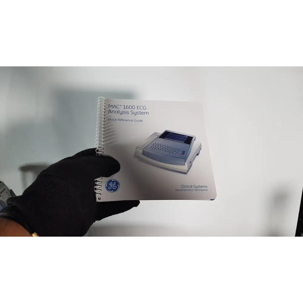 White spiral-bound quick reference guide for the medical mac1600 ecg analysis system accompanying the cart stand extras