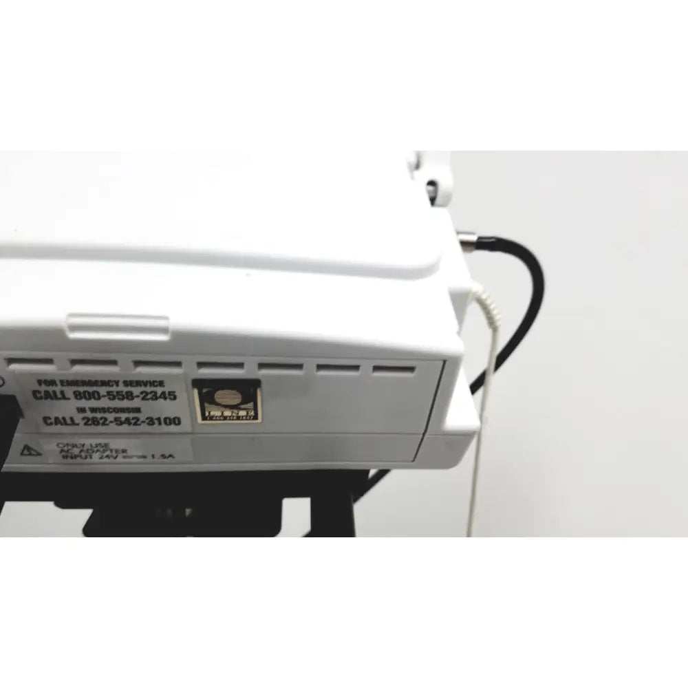 White ge medical mini-torr plus patient monitor ref 3444 with black cables and emergency contact label on rolling stand