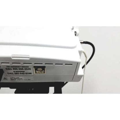 White ge medical mini-torr plus patient monitor ref 3444 with black cables and emergency contact label on rolling stand