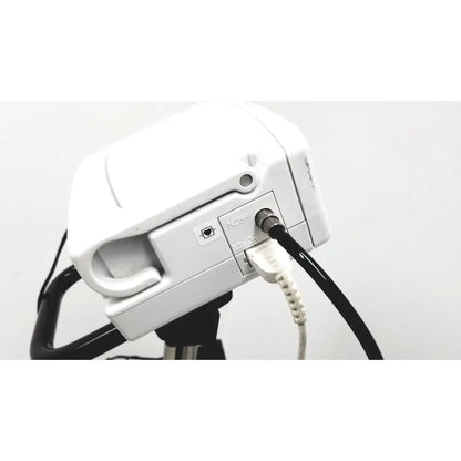 White plastic camera mount with black tripod base and connected cables on the back of ge medical plus patient monitor ref 3444