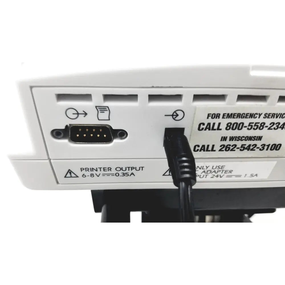 Black power cable plugged into the back of white ge medical mini-torr plus patient monitor ref 3444 24v input port
