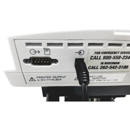 Black power cable plugged into the back of white ge medical mini-torr plus patient monitor ref 3444 24v input port