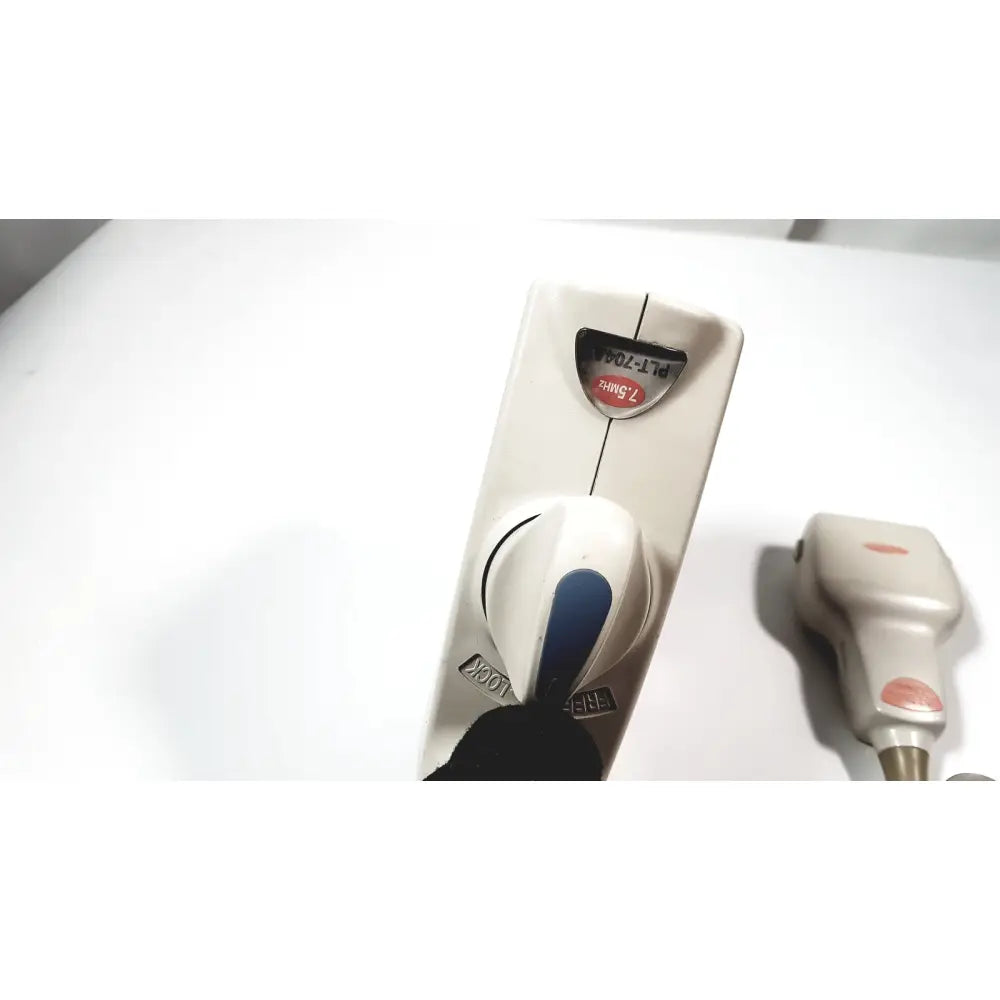 White plastic handheld laser hair removal device with blue dial accent and engraved model number for medical systems use