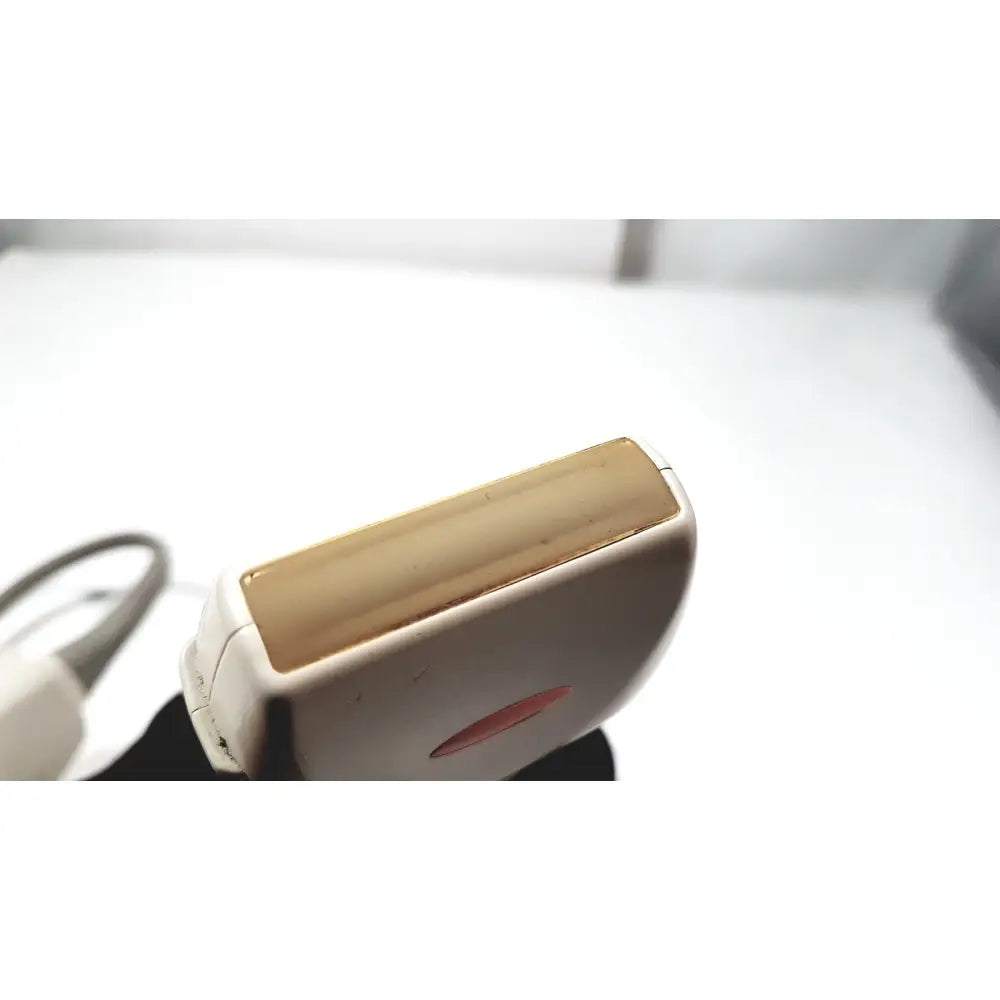 White and gold electric epilator with sleek ergonomic design featured alongside ge medical systems ultrasound convex array transducer