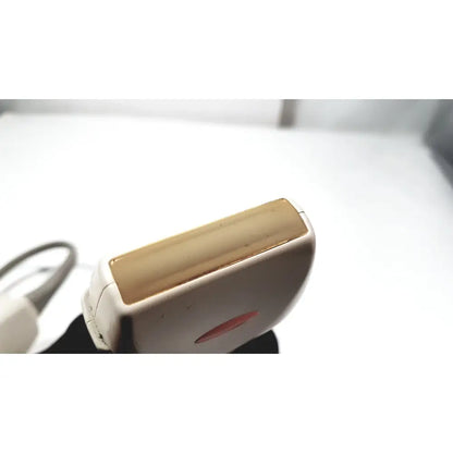 White and gold electric epilator with sleek ergonomic design featured alongside ge medical systems ultrasound convex array transducer