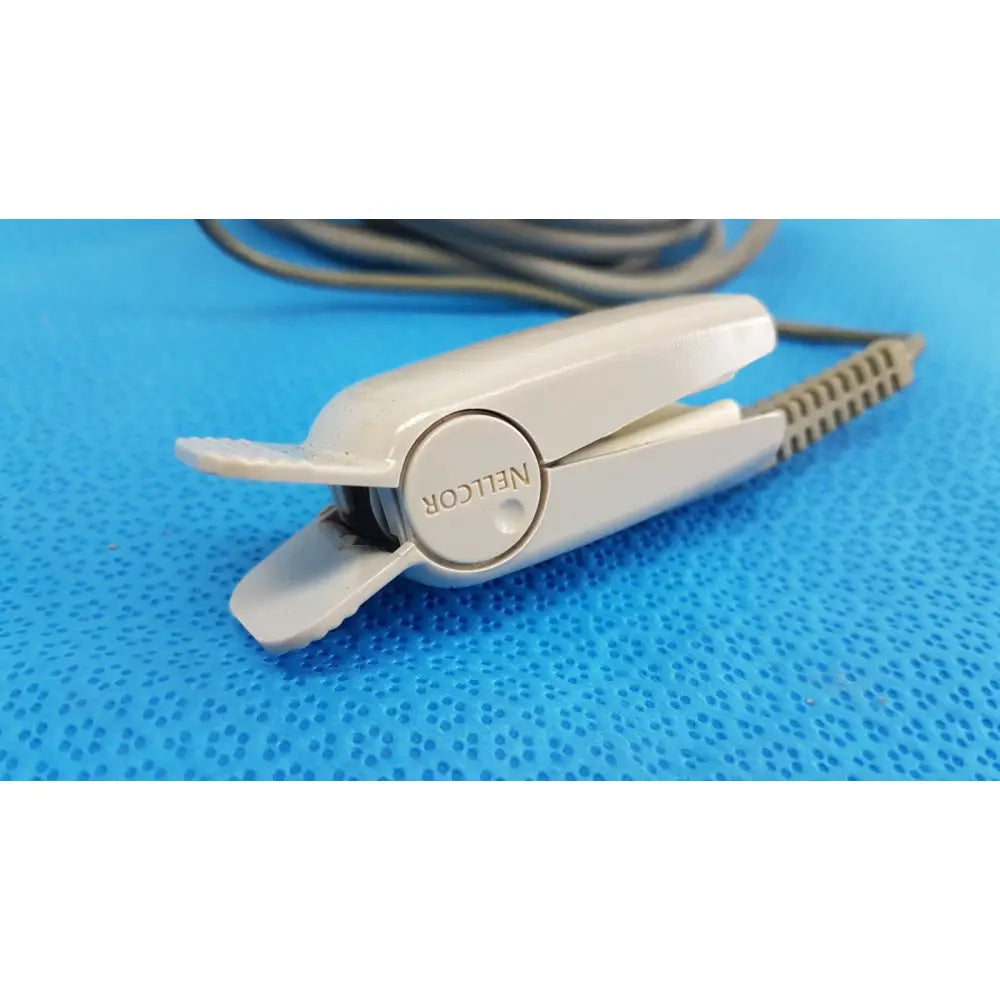 White plastic nelcor hair straightener with textured grip and coiled cord for ge spo2 interface cable use