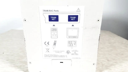 White rectangular GE tram-rac 4a module rack showing back side with two blue-labeled tram-net ports and schematic diagrams