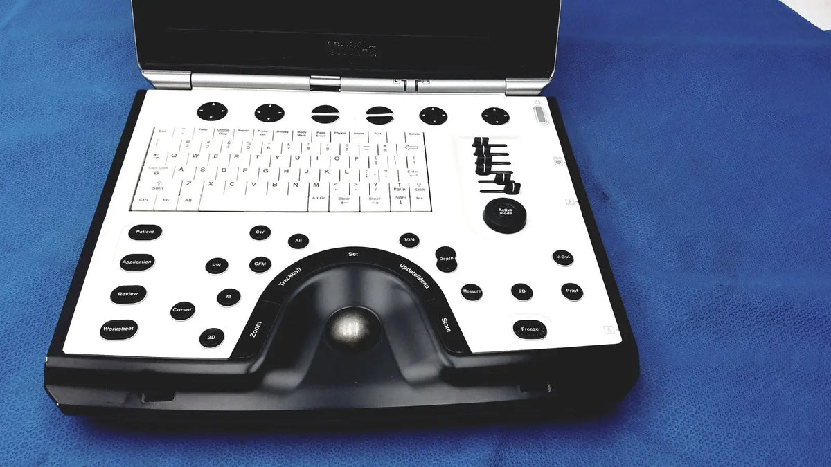 Black and white GE Vivid portable ultrasound machine with keyboard, circular buttons, and integrated trackball for mobile use