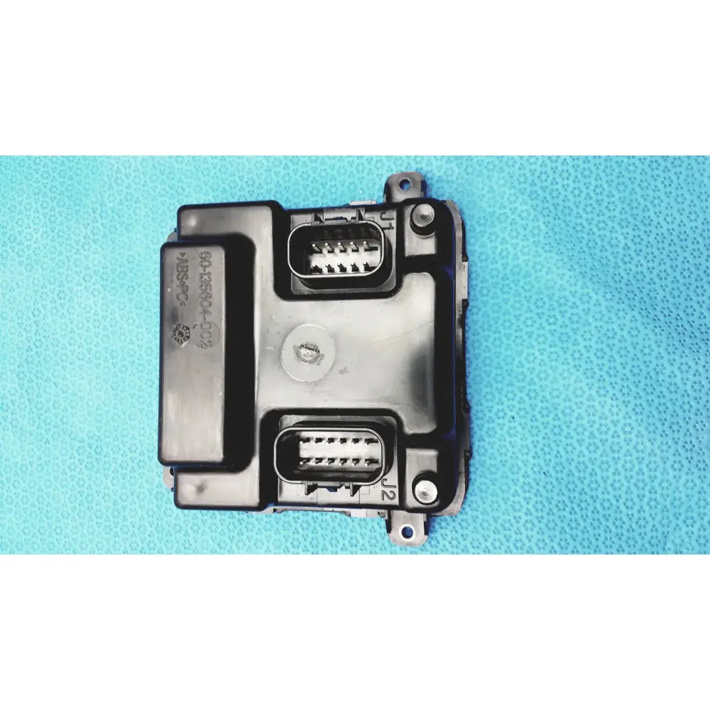 Black plastic gem driver display control module with two rectangular connector ports and circular screw fastener back side