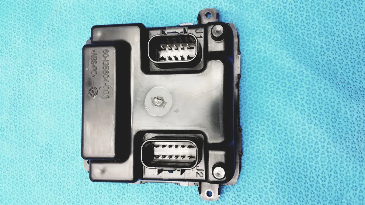 Black plastic gem driver display control module with two rectangular connector ports and circular screw fastener back side