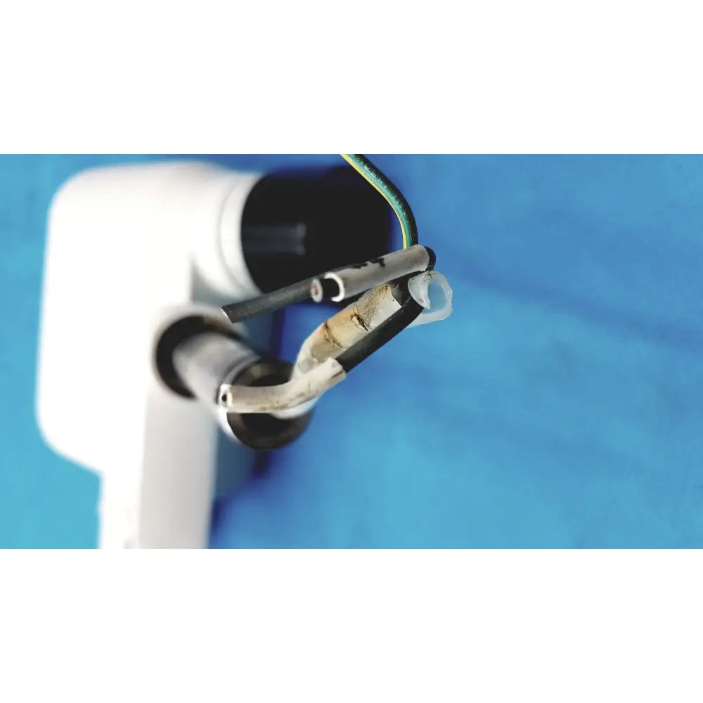 White plastic electrical outlet with exposed wires and corroded metal connector on the back of gendex 770 tube head for imaging equipment reuse medical