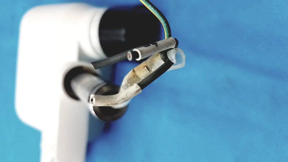 White plastic electrical outlet with exposed wires and corroded metal connector on the back of gendex 770 tube head for imaging equipment reuse medical