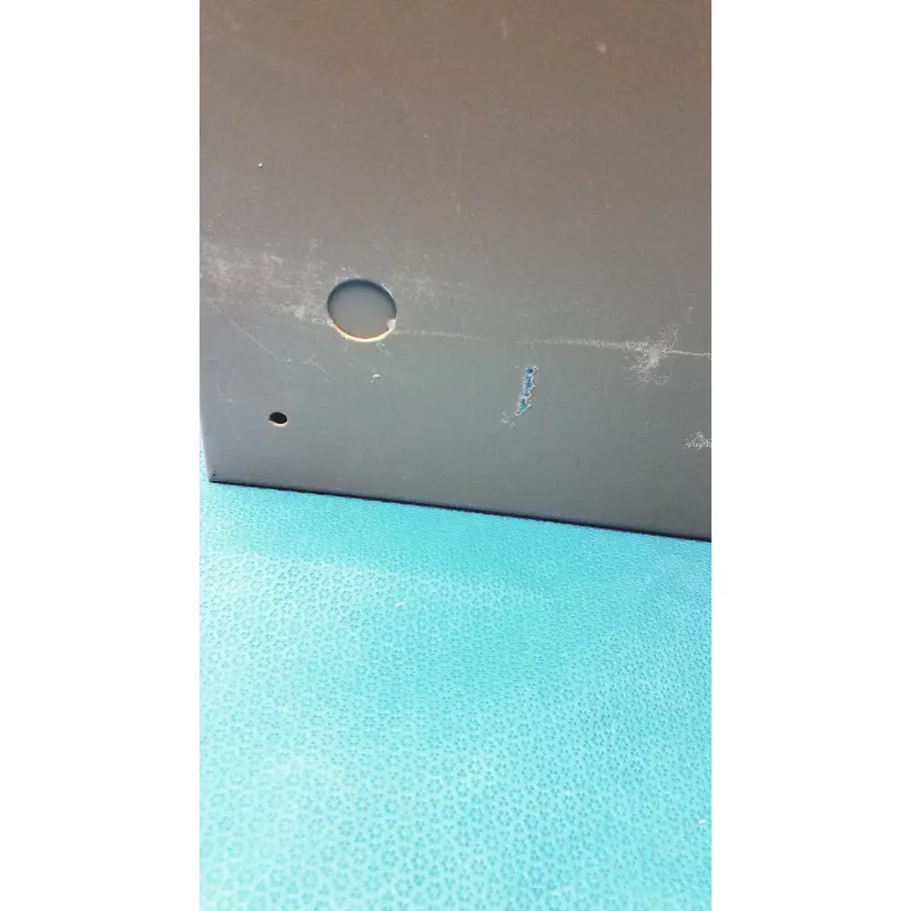 Gray metal plate with circular hole on textured turquoise surface for general purpose medium steel nema 1 enclosure