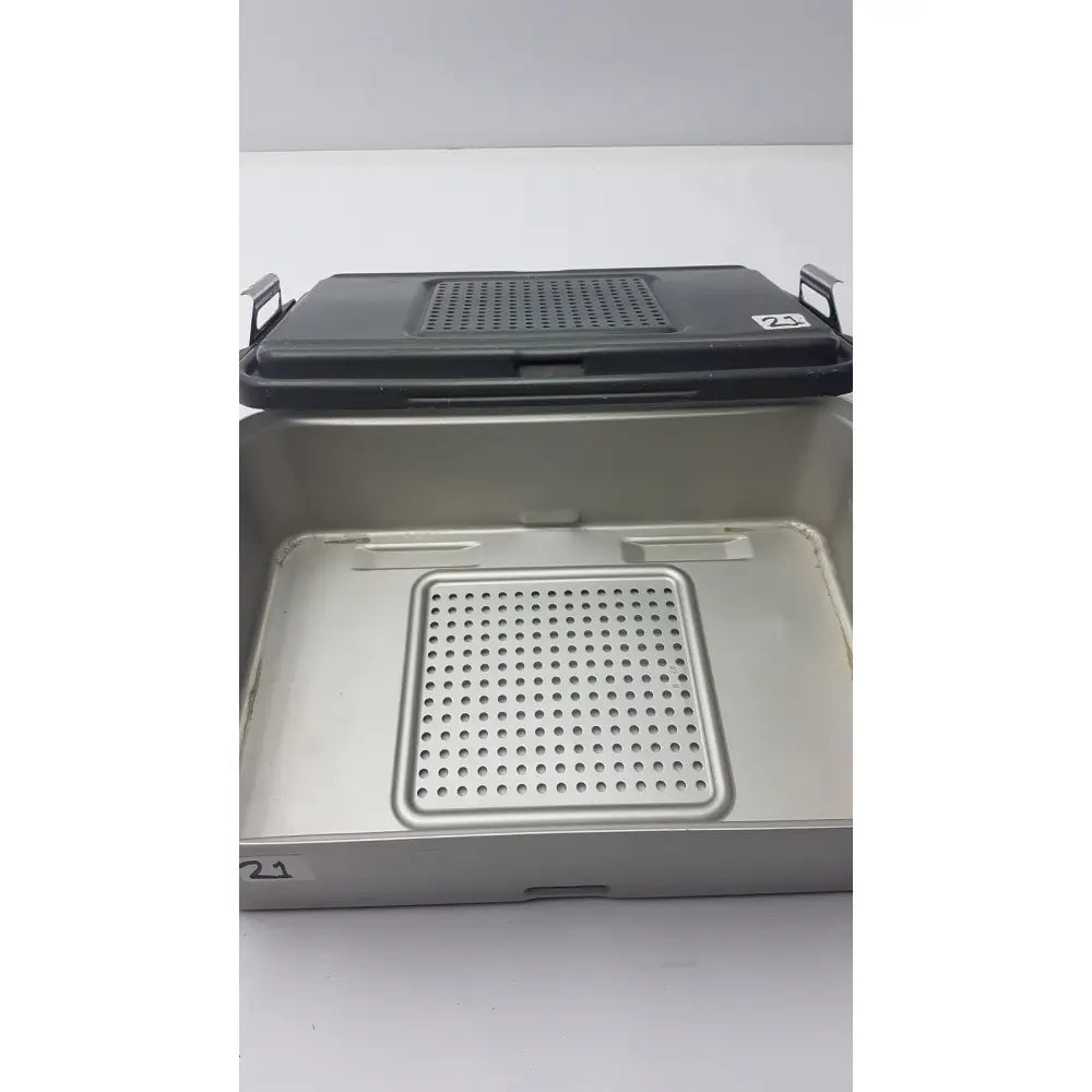 Genesis solid brass sterilization container with black perforated lid and silver metal tray with matching insert