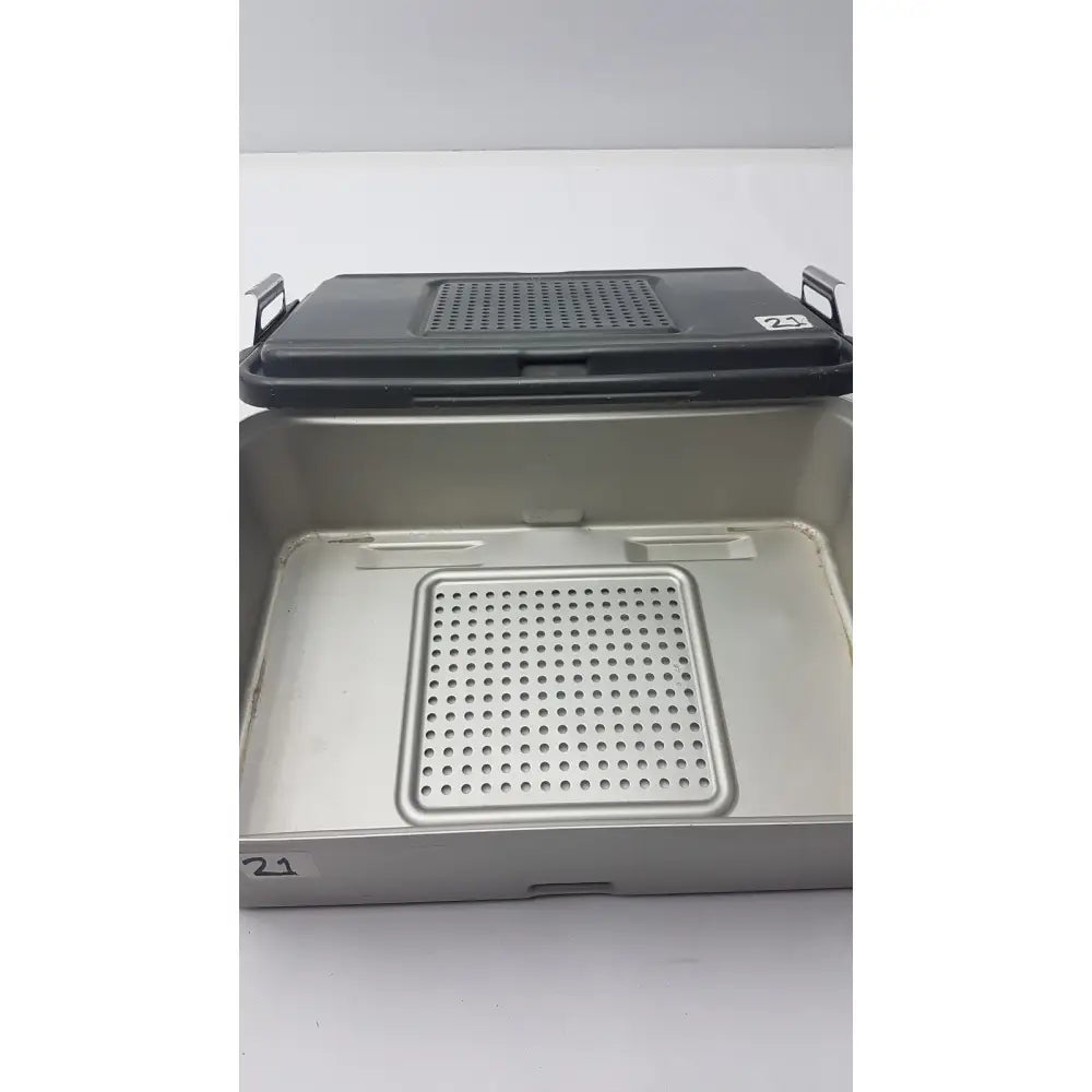 Genesis solid brass sterilization container with black lid and perforated tray for surgical instrument sterilization