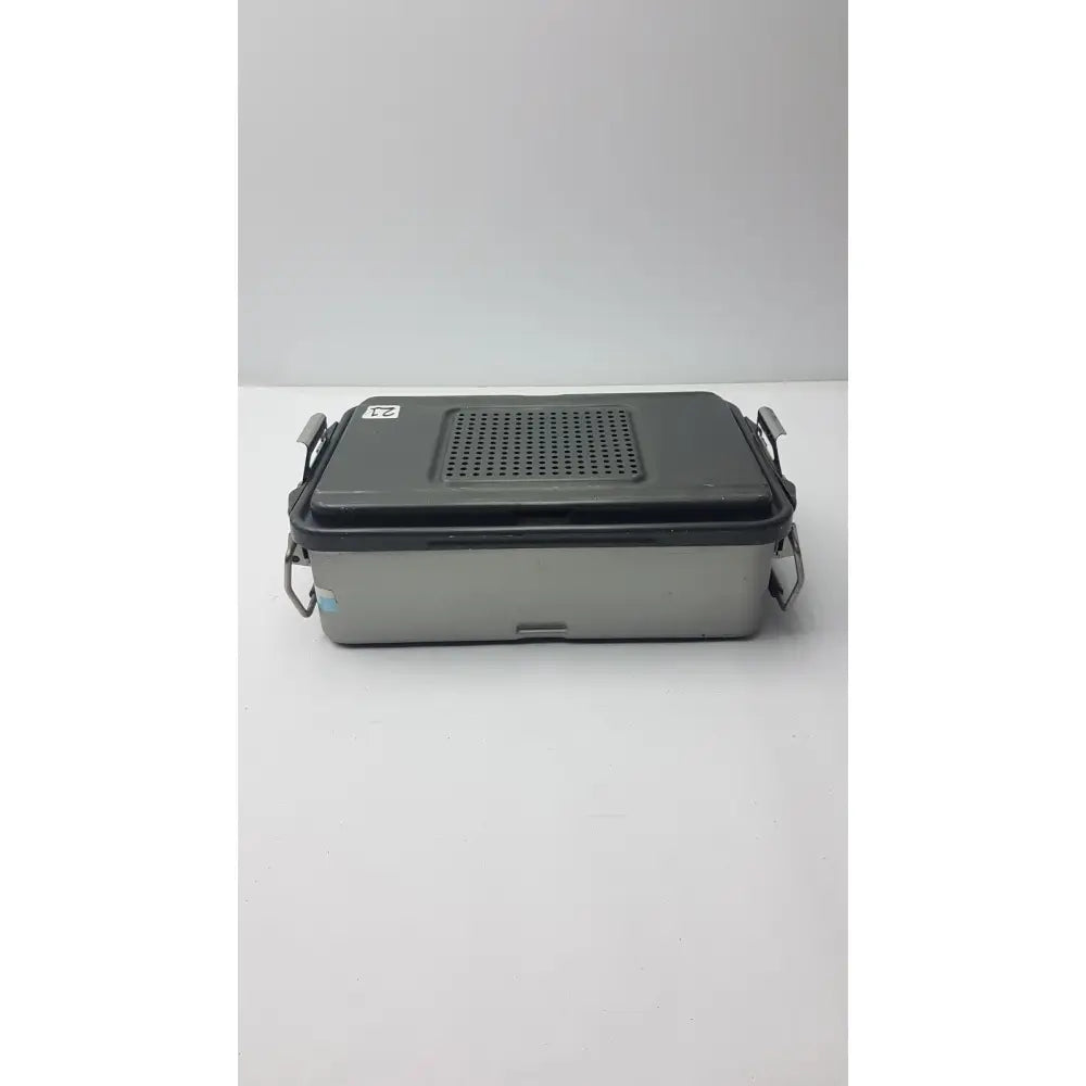 Gray and black two-tone genesis solid brass sterilization container with perforated lid and metal latches for surgical use