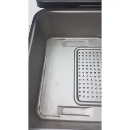 Silver metal baking pan with perforated grid insert and raised handles for genesis solid brass sterilization container use