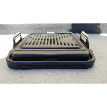 Black plastic genesis sterilization container half lid with perforated surface and metal handles for secure grip