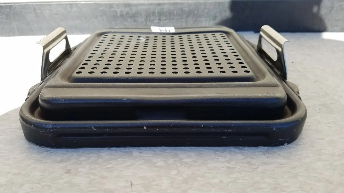 Black plastic genesis sterilization container half lid with perforated surface and metal handles for secure grip