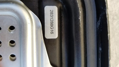 A white alphanumeric sticker on the black genesis sterilization container half lid affixed to a dark curved surface