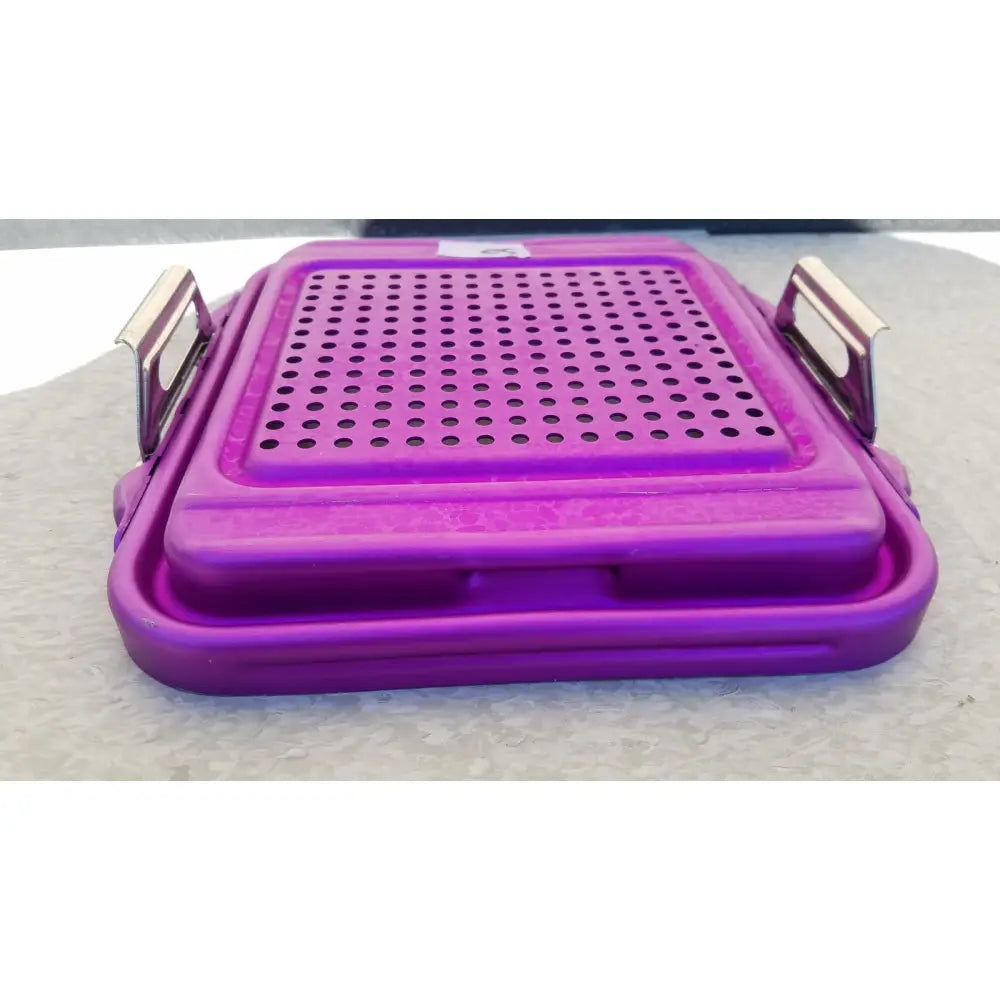 Purple plastic genesis sterilization container half lid with perforated top and metallic handles for medical use