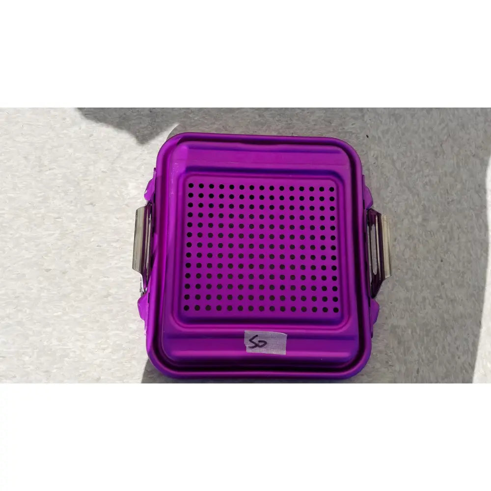 Purple genesis sterilization container half lid made of plastic with perforated top and metallic side clips for secure closure