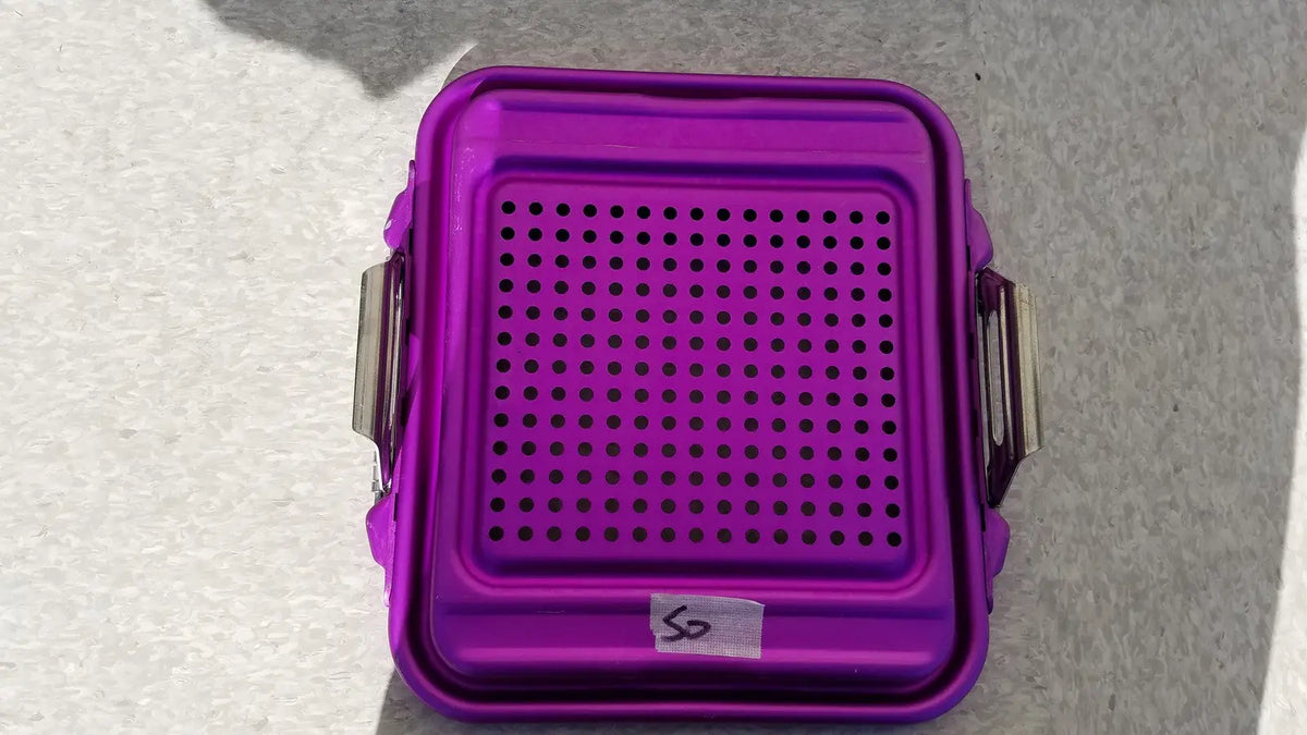 Purple genesis sterilization container half lid made of plastic with perforated top and metallic side clips for secure closure