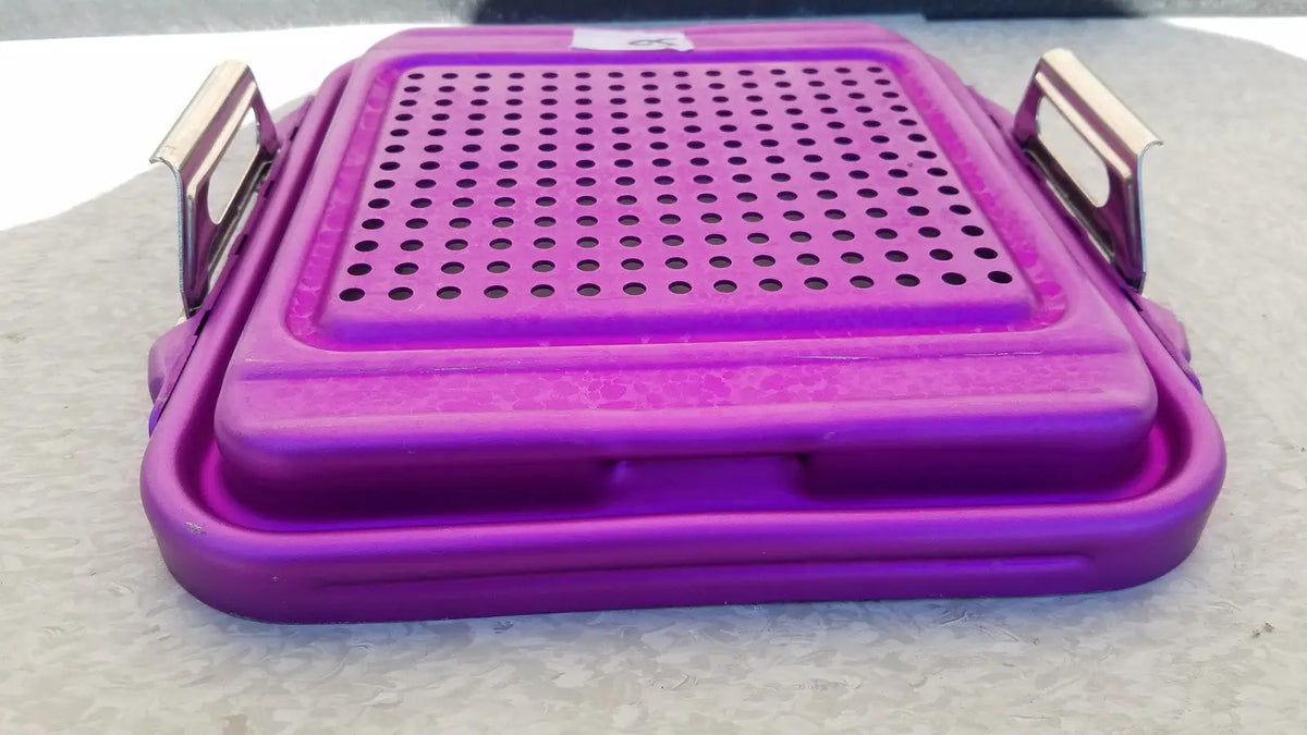 Purple plastic genesis sterilization container half lid with perforated top and metallic handles for medical use