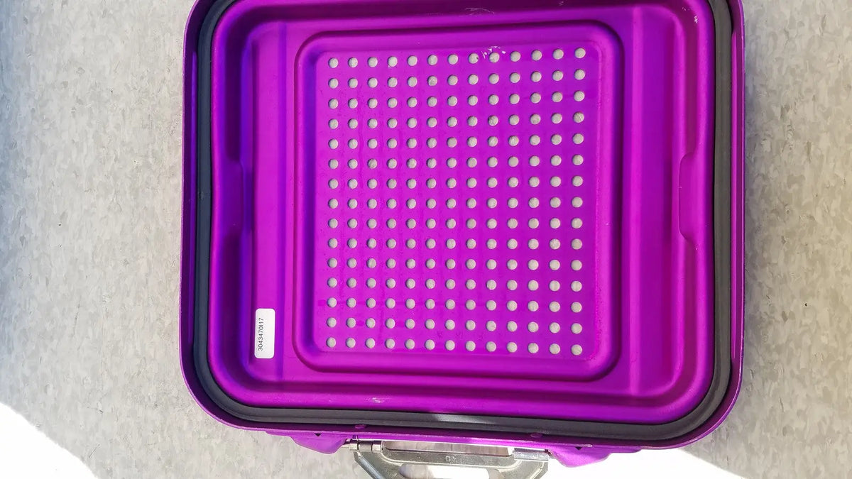Purple plastic genesis sterilization container half lid with black rim and perforated surface for sterilization use