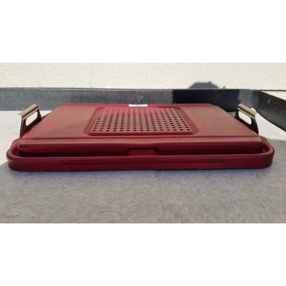 Red plastic genesis sterilization container half lid with perforated surface and metallic handles for secure closure