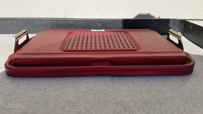 Red plastic genesis sterilization container half lid with perforated surface and metallic handles for secure closure