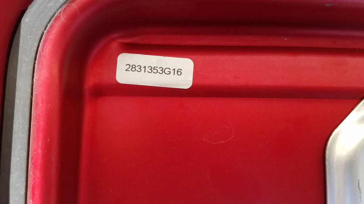 Red plastic genesis sterilization container half lid with white label showing serial number 2831353g16
