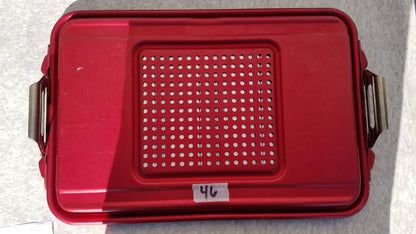 Red plastic genesis sterilization container half lid with perforated design and metal side handles for secure storage