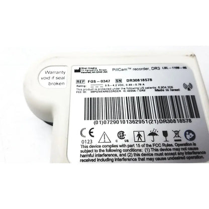 White plastic pillcam recorder data dr3 with rounded casing and printed regulatory labels from given imaging fgs-0347