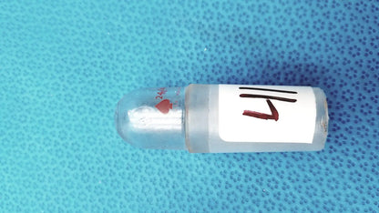 Clear plastic glass lab stopper with white 1/4 inch label and red heart symbol for ground glass lab use