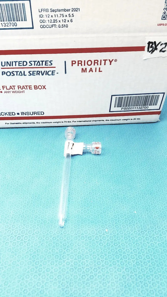 Clear plastic medical syringe with white plunger on blue surface next to glass schlenk storage tube with high vacuum ptfe valve