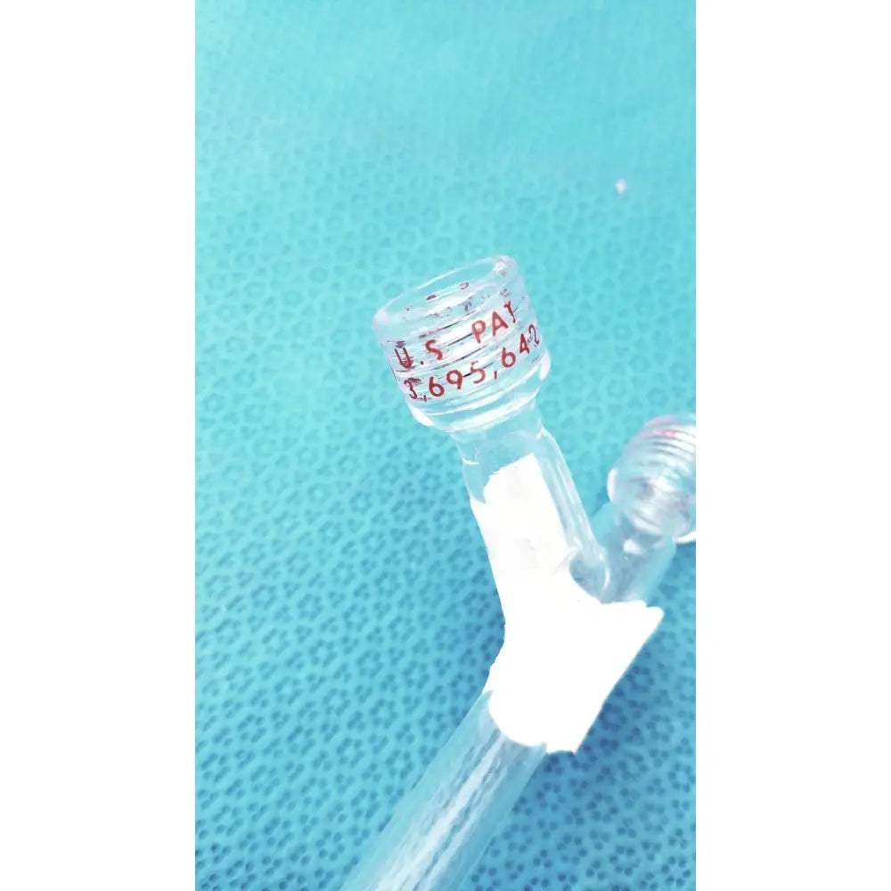 Clear glass schlenk storage tube with red engraved patent markings and white tape wrap featuring high vacuum ptfe valve