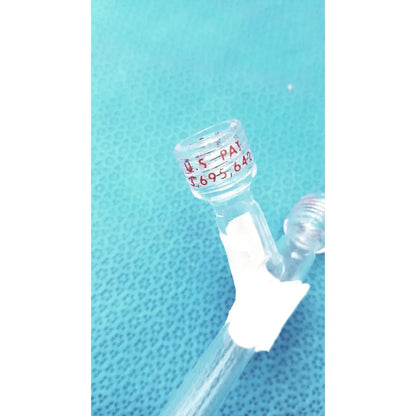 Clear glass schlenk storage tube with red engraved patent markings and white tape wrap featuring high vacuum ptfe valve