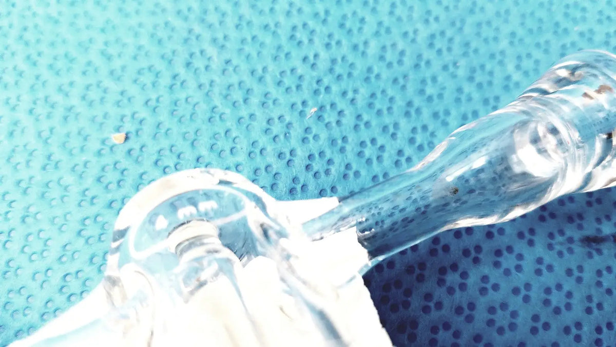 Clear glass stopcock valve adapter with curved neck and textured surface made of borosilicate for lab control use