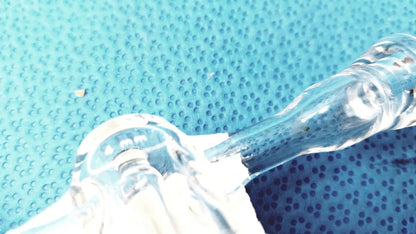 Clear glass stopcock valve adapter with curved neck and textured surface made of borosilicate for lab control use