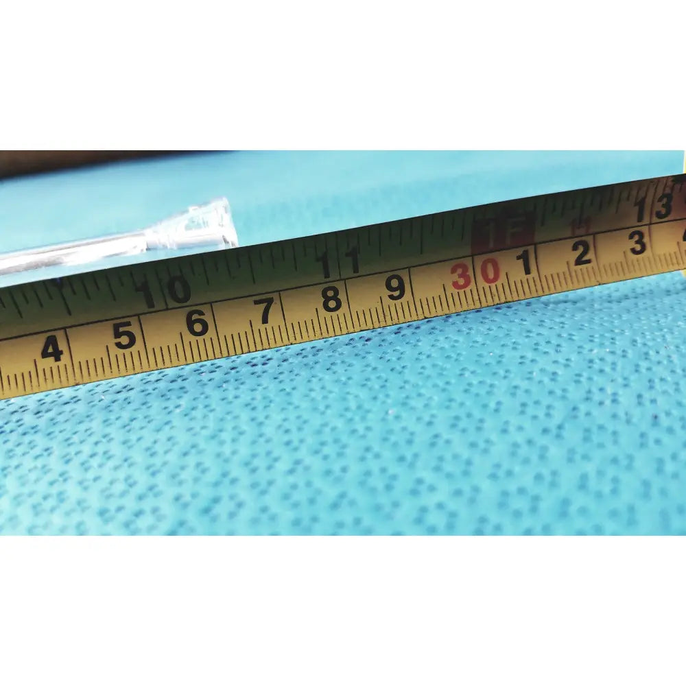 Yellow metal ruler with black and red markings on blue surface near a glass straight bore ground glass valve stopcock