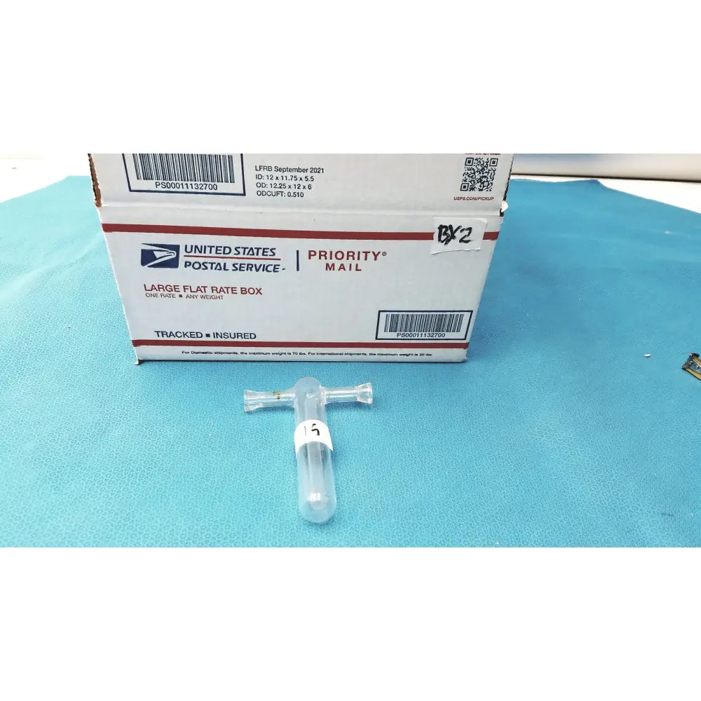Clear plastic test tube with cross-shaped cap and white label marked 15 paired with glass Tenbroeck tissue grinder pestle