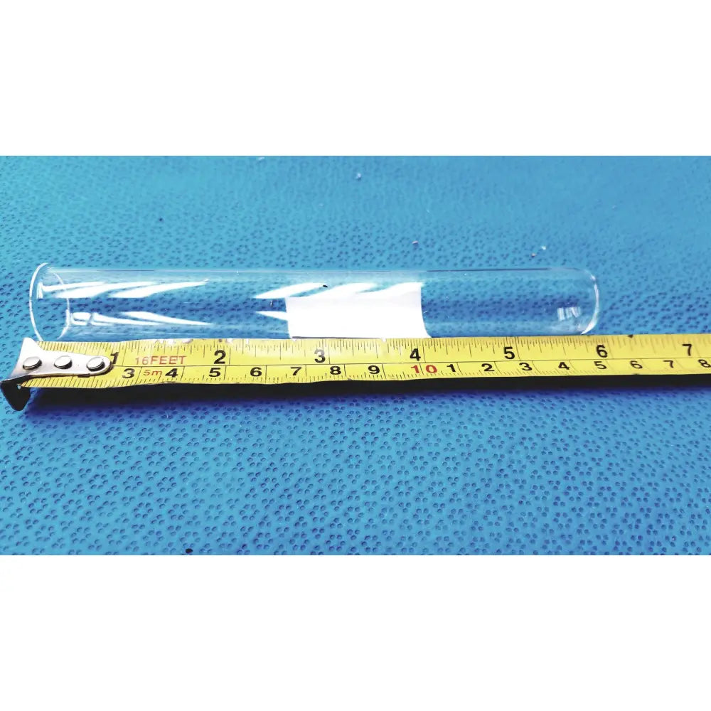 Clear glass borosilicate test tube 25x150mm with white label resting on yellow measuring tape for lab use