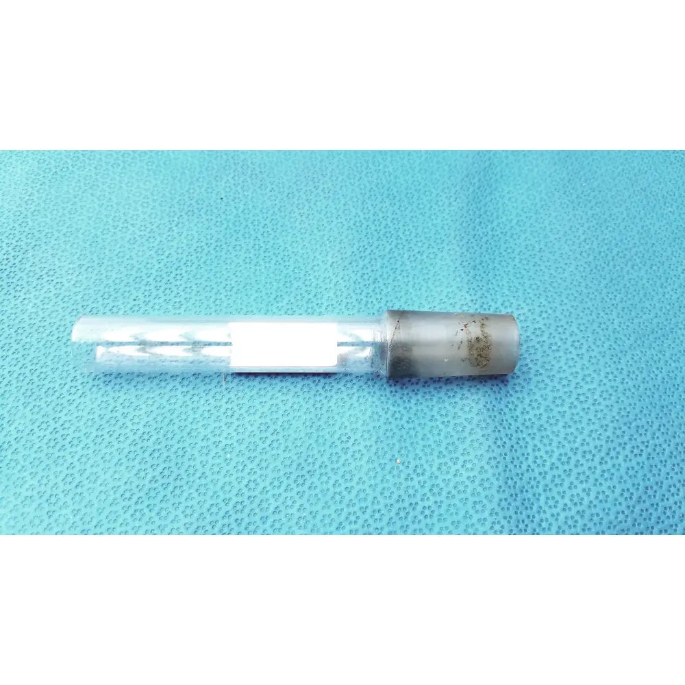 Clear glass thermometer adapter vial with metallic cap containing white tablets showing wear on cap for laboratory use