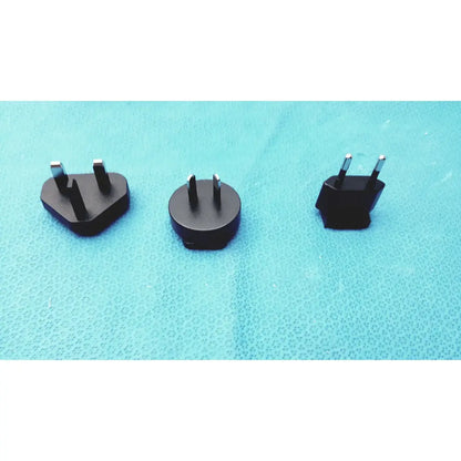 Three black travel plug adapters with metallic prongs for international use compatible with glidescope video monitor an162878
