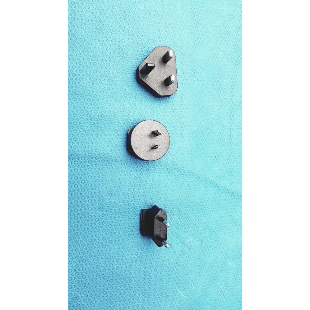 Three distinct metallic and black plastic power plugs with varying pin configurations on the glidescope video monitor an162878