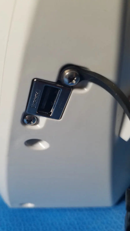 Black usb port with metallic screws on the back of a light gray glidescope video monitor device