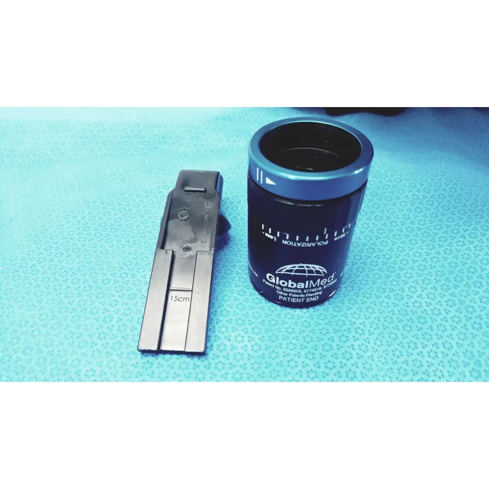Blue cylindrical globalmed patient end polarizer with silver metallic lid and measurement markings in globalmed telemedicine kit