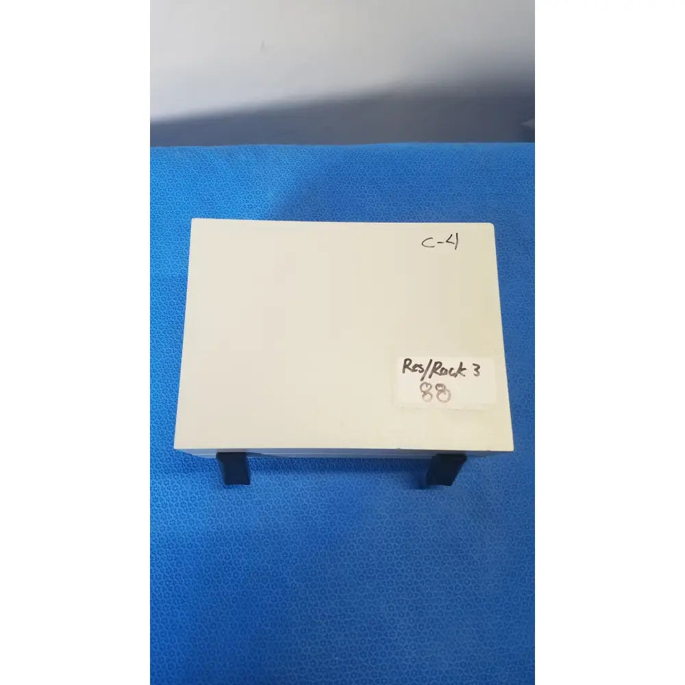 A cream-colored gms general microwave c f band 6.2-6.8 GHz receiver monitor with black stand supports and minimalist design